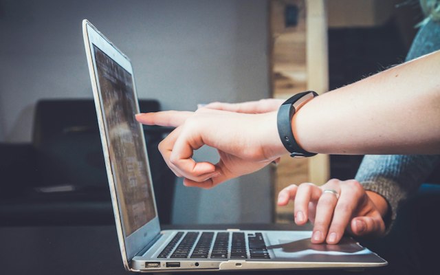 Hands demonstrating a task on a laptop